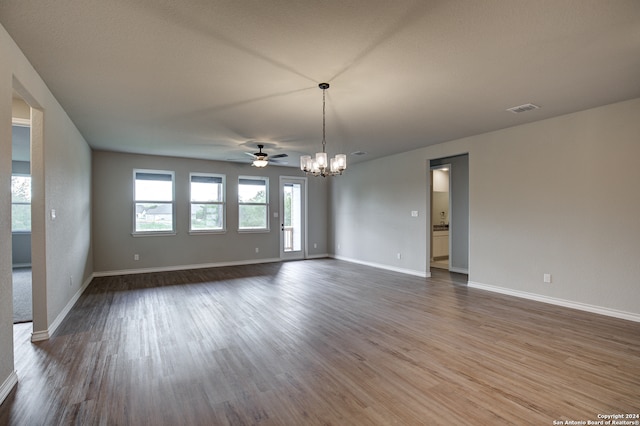 spare room featuring dark hardwood / wood-style floors and ceiling fan with notable chandelier