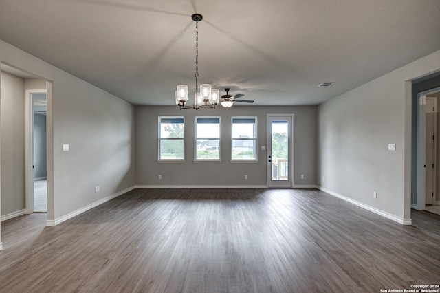 empty room with dark wood-type flooring and ceiling fan with notable chandelier