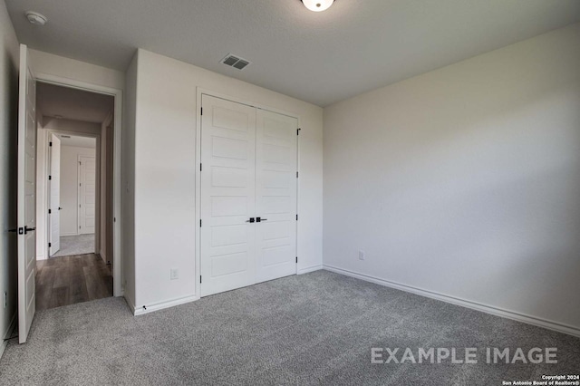 unfurnished bedroom featuring carpet floors and a closet