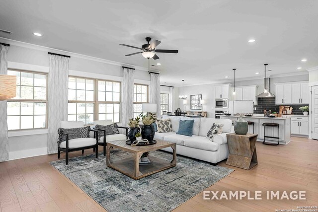 living room with ceiling fan, ornamental molding, and light hardwood / wood-style floors