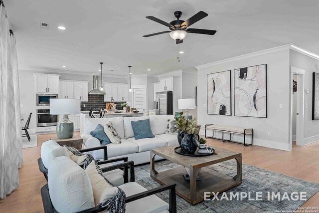 living room featuring ceiling fan, light hardwood / wood-style floors, and crown molding