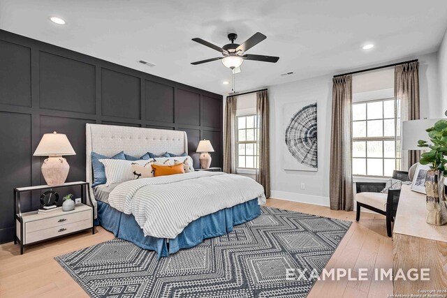 bedroom with multiple windows, light hardwood / wood-style flooring, and ceiling fan