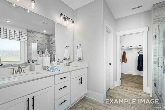 bathroom featuring a shower with door, vanity, and wood-type flooring