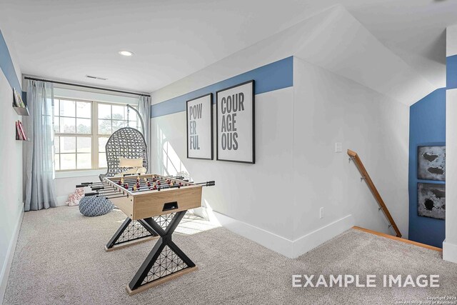 recreation room featuring lofted ceiling and carpet