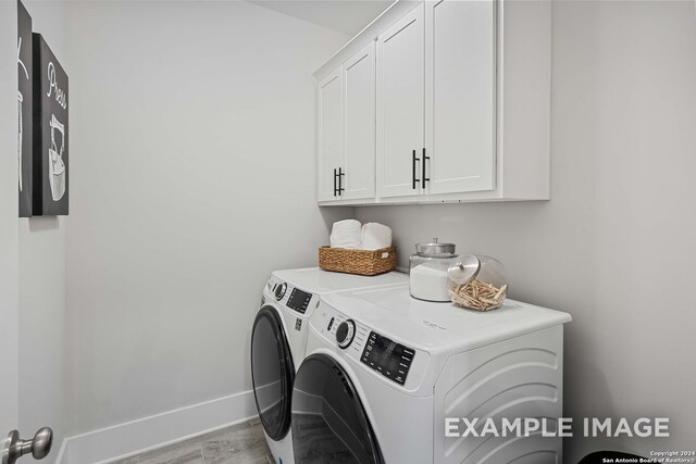 washroom featuring washer and dryer and cabinets