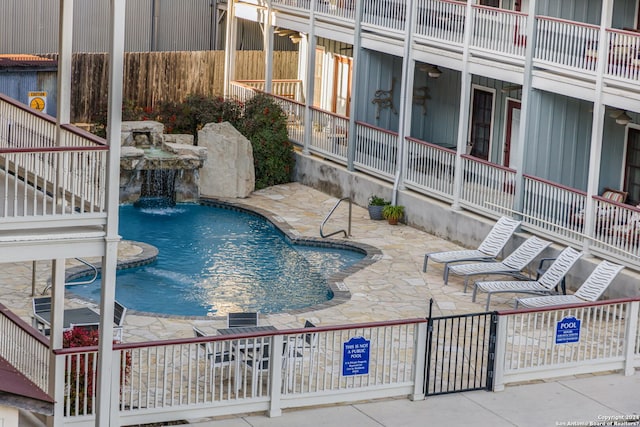 view of pool featuring pool water feature and a patio