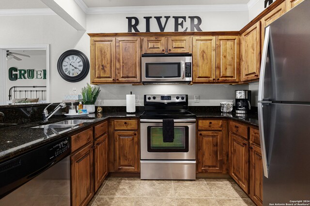 kitchen with ceiling fan, light tile floors, dark stone counters, sink, and stainless steel appliances