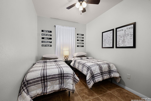 bedroom with dark tile floors and ceiling fan