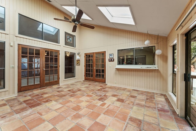 unfurnished sunroom with ceiling fan, french doors, and lofted ceiling with skylight