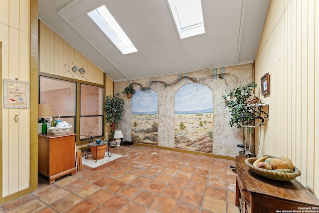 interior space with a healthy amount of sunlight, lofted ceiling, and wooden walls