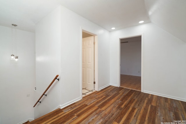 unfurnished room featuring dark wood-type flooring and lofted ceiling