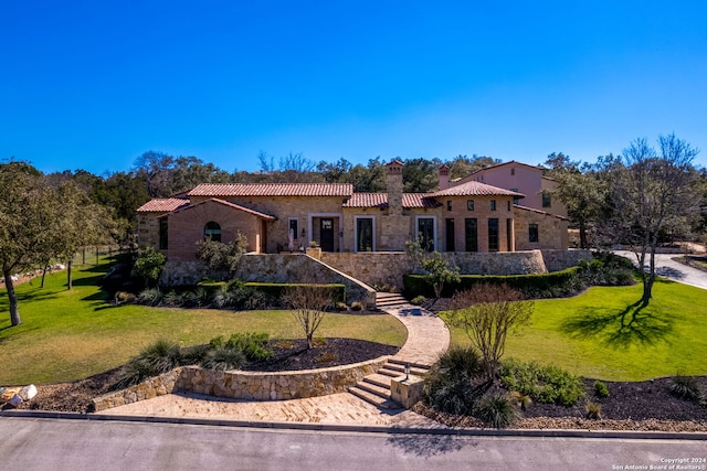 mediterranean / spanish-style home with a front yard