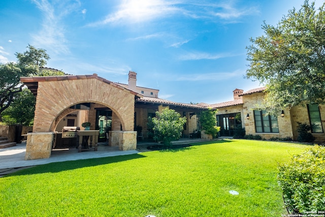 back of property with a patio and a yard