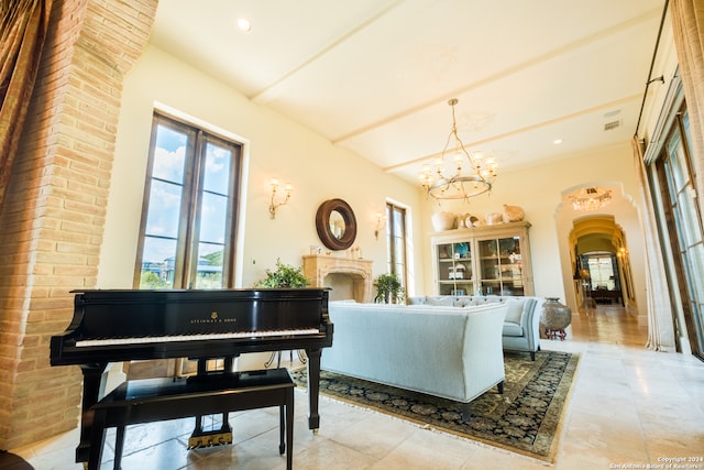 living room featuring a notable chandelier, light tile patterned floors, and brick wall