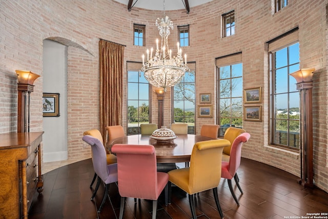 dining space with a towering ceiling and brick wall