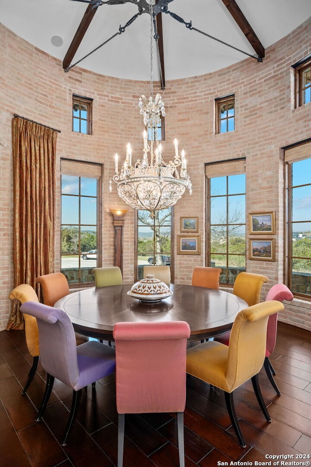 dining area featuring dark hardwood / wood-style flooring, a notable chandelier, a high ceiling, beamed ceiling, and brick wall