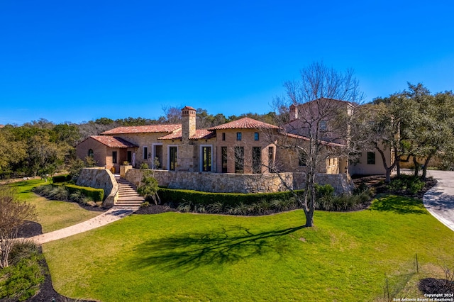 rear view of property featuring a lawn