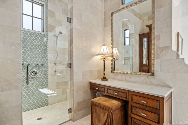 bathroom with tile walls, vanity, and an enclosed shower