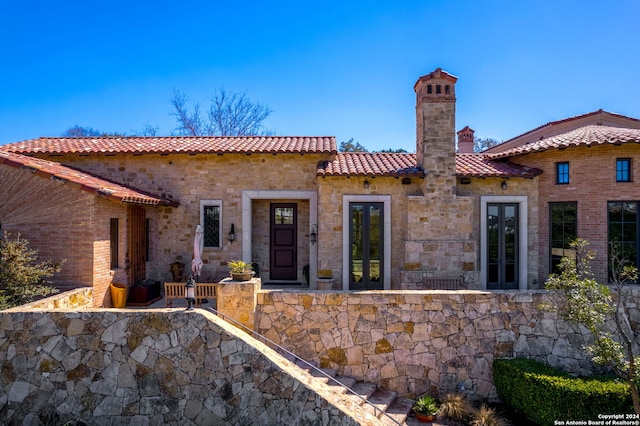 mediterranean / spanish-style home with french doors and a patio area