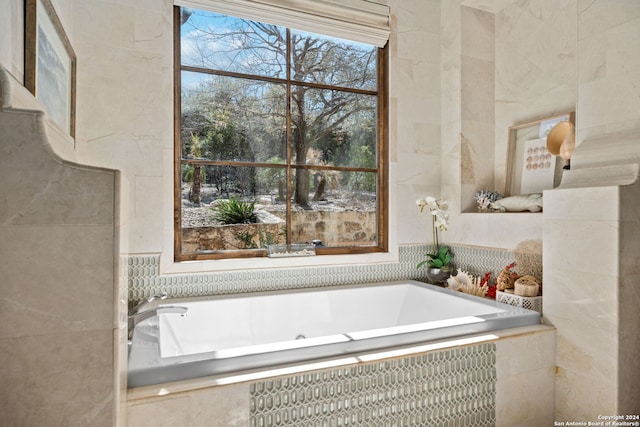 bathroom with tile walls and tiled bath