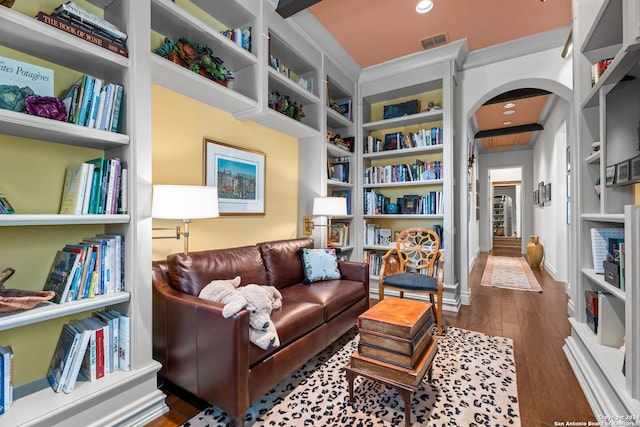 living area with dark wood-type flooring and built in features