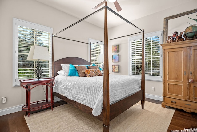 bedroom with ceiling fan, wood-type flooring, and multiple windows