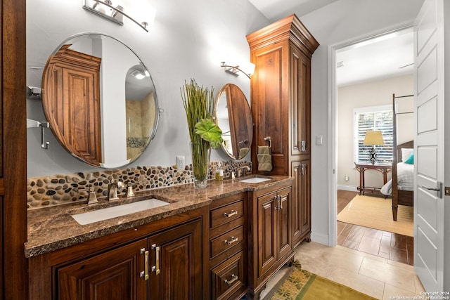 bathroom with double sink vanity, tasteful backsplash, and tile patterned flooring