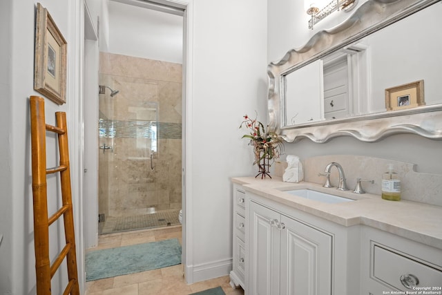 bathroom featuring toilet, vanity, a shower with shower door, and tile patterned flooring