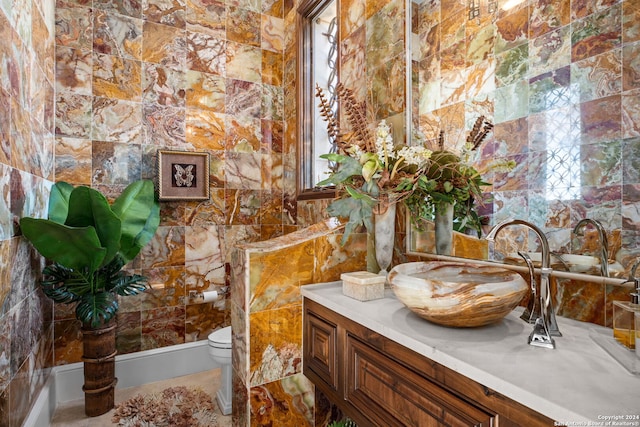 bathroom with vanity, tile walls, toilet, and tile patterned flooring