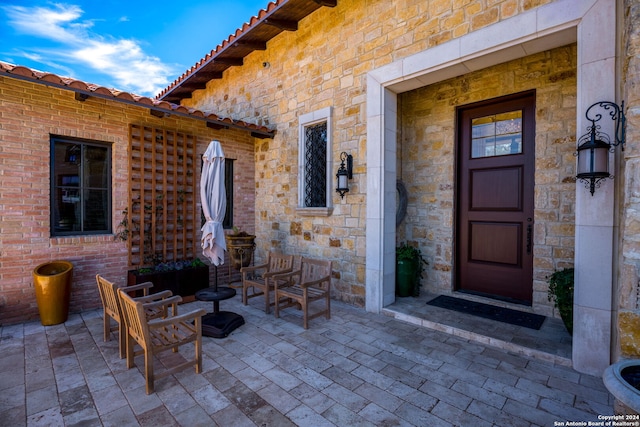 view of exterior entry featuring a patio and an outdoor living space