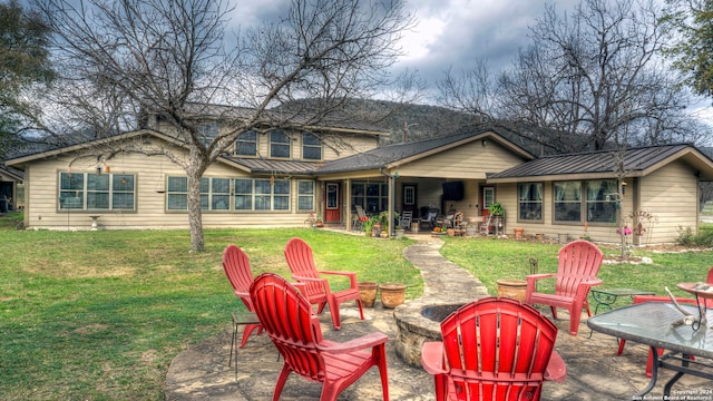 rear view of property with a yard and a patio