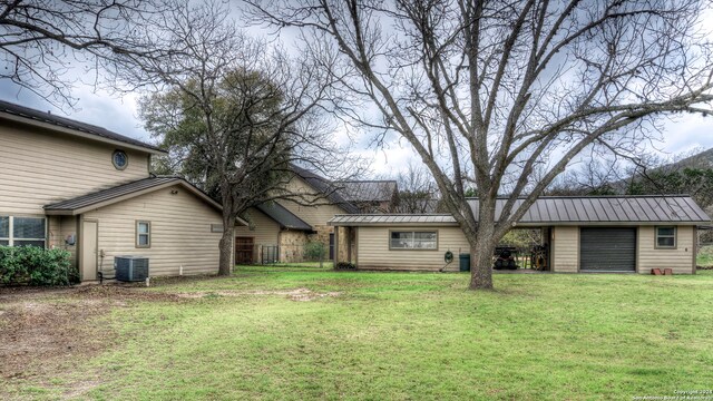 back of property with central AC and a yard