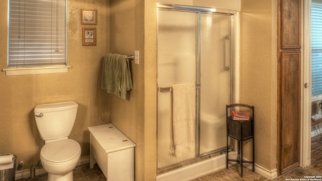 bathroom with toilet and a shower with shower door