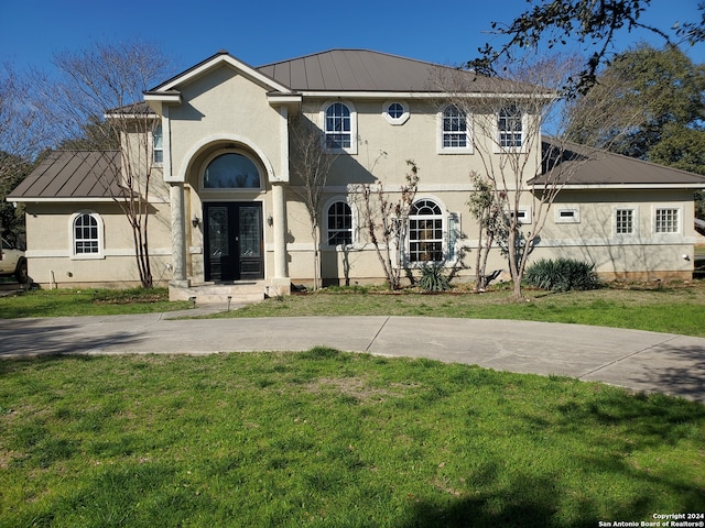 mediterranean / spanish-style home with french doors and a front lawn