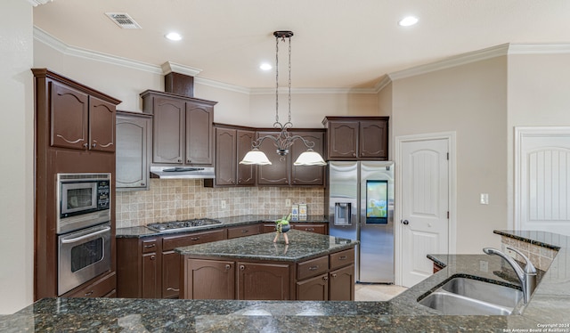 kitchen featuring a kitchen island with sink, sink, hanging light fixtures, dark brown cabinets, and stainless steel appliances