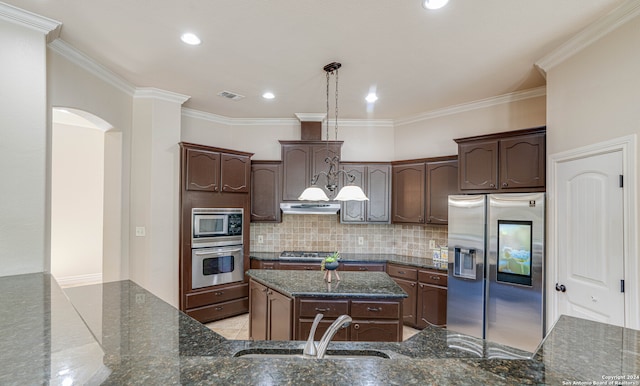 kitchen featuring sink, hanging light fixtures, stainless steel appliances, dark stone countertops, and a kitchen island