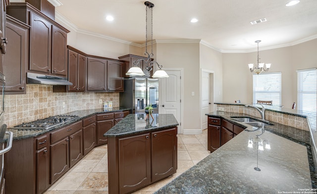 kitchen featuring sink, a center island, hanging light fixtures, dark stone countertops, and appliances with stainless steel finishes