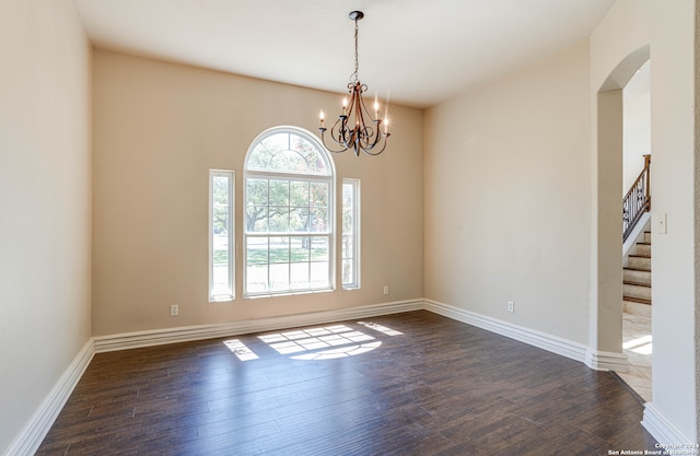 unfurnished room with dark hardwood / wood-style flooring and a chandelier