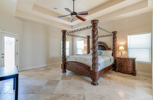 bedroom featuring a raised ceiling and ceiling fan