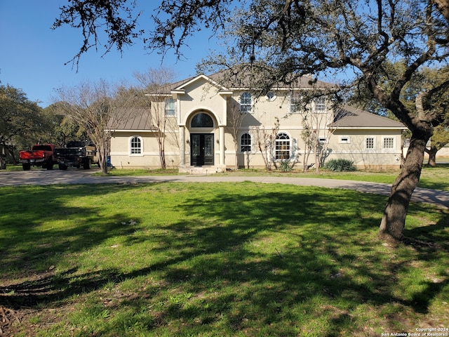 mediterranean / spanish home featuring a front lawn