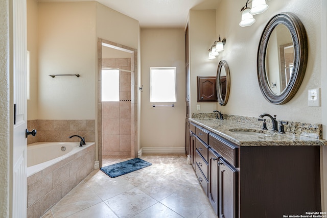 bathroom with vanity, tile patterned floors, and tiled tub