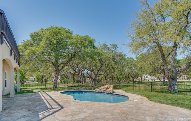 view of swimming pool featuring a patio area and a yard