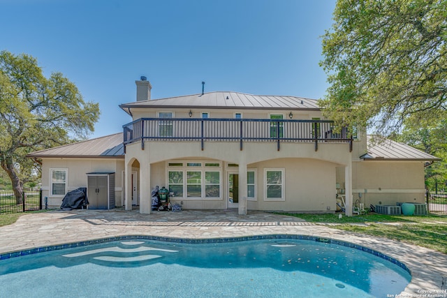 back of house with a fenced in pool, cooling unit, and a patio