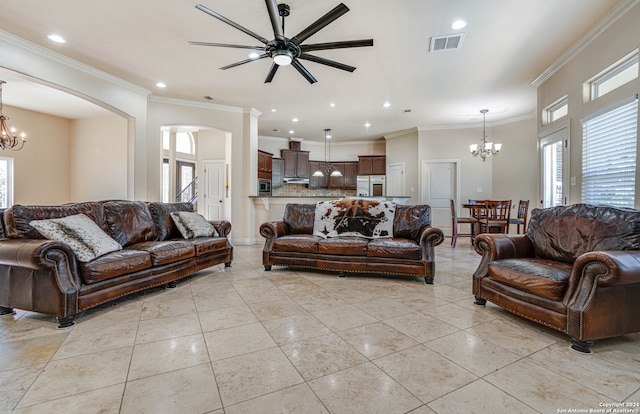 living room featuring light tile patterned floors, ceiling fan with notable chandelier, and crown molding