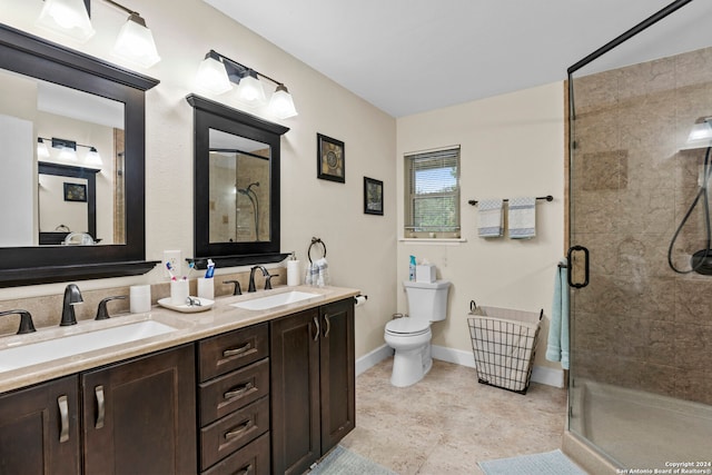 bathroom featuring toilet, dual bowl vanity, a shower with door, and tile flooring