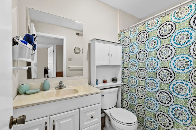 bathroom with toilet and vanity with extensive cabinet space