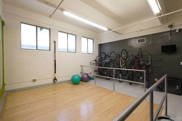 exercise room with light hardwood / wood-style flooring