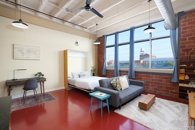 bedroom with ceiling fan, a wood stove, brick wall, and concrete floors