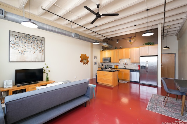 living room featuring ceiling fan, a high ceiling, sink, and rail lighting