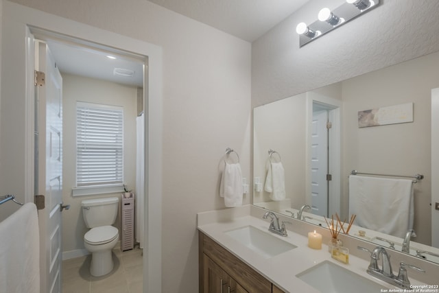 bathroom featuring double sink vanity, toilet, and tile flooring